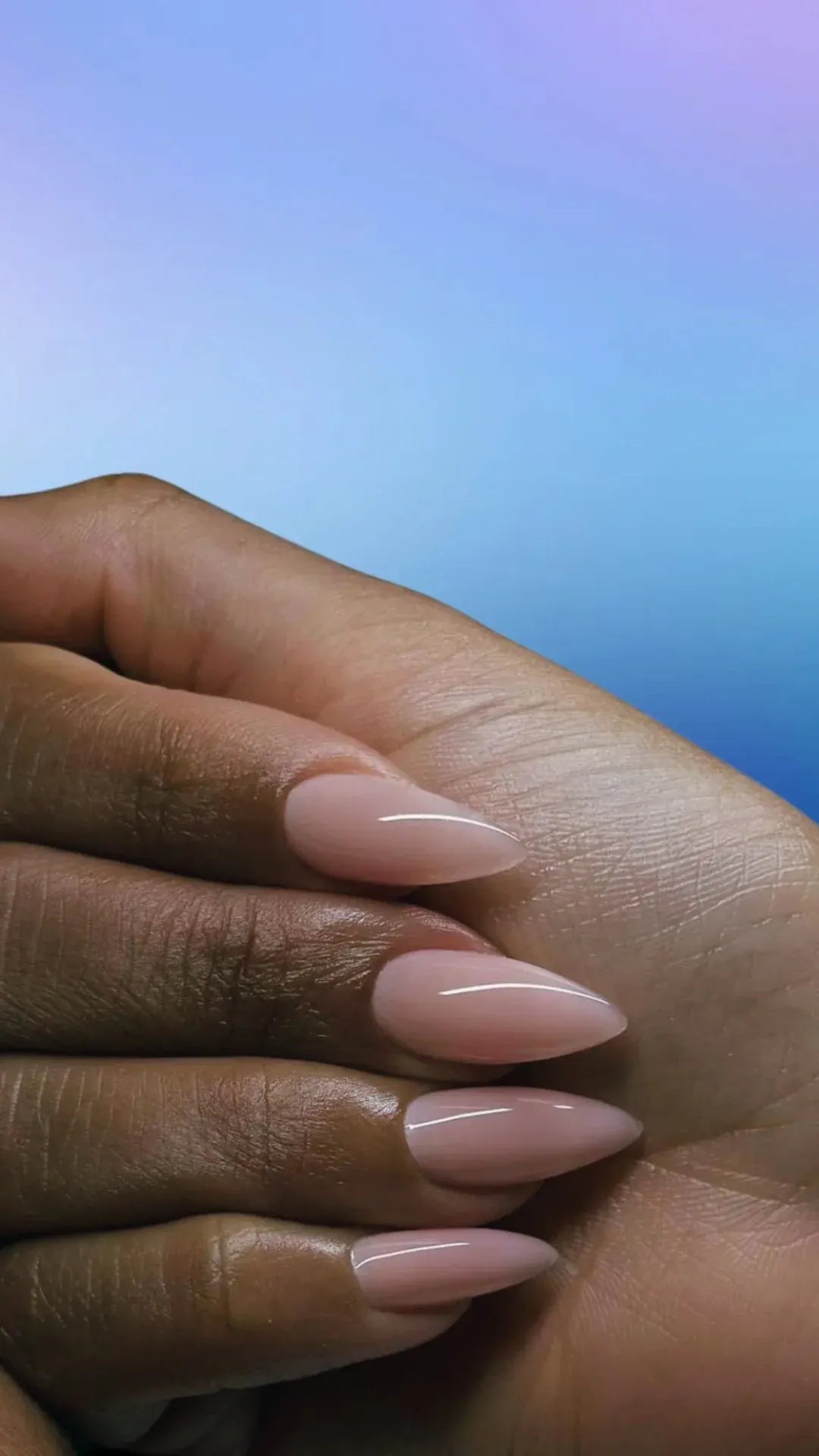 Nude almond nails against a holographic gradient